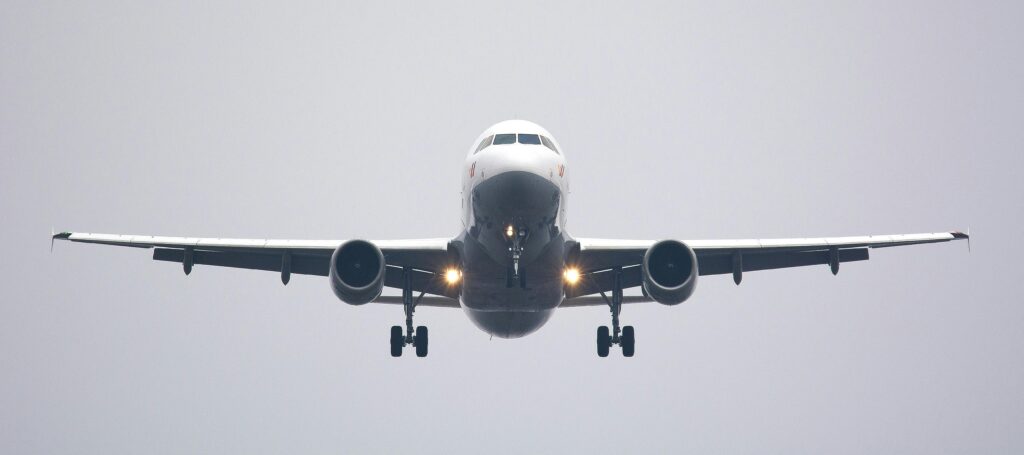 pexels-photo-358319-358319 A commercial airliner captured head-on, preparing to land against a cloudy sky.